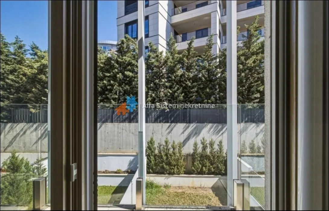 View through the window overlooking green areas and the building courtyard.