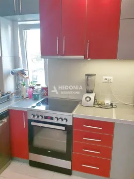Manja kuhinja sa crvenim elementima i šporetom. - image 3