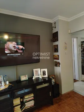 Dnevna soba sa televizorom na zidu i komodom ispod. - image 3