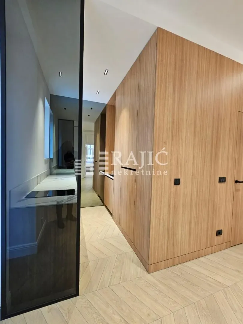 Modern kitchen with wooden paneling and built-in appliances.