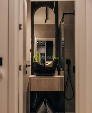 View of a modernly decorated bathroom with a washbasin and a mirror. - image 2