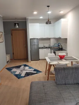 Open-plan living room with dining area and kitchen. - image 6