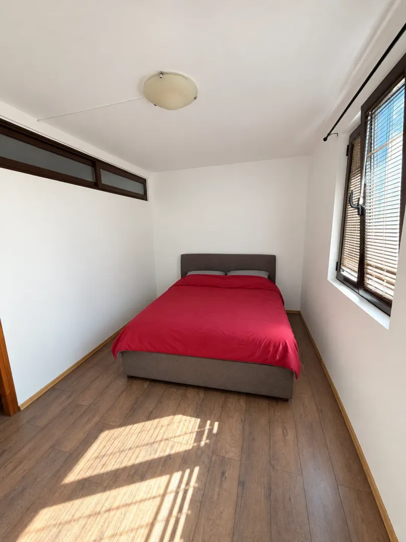 Bedroom with a double bed and a window with blinds.