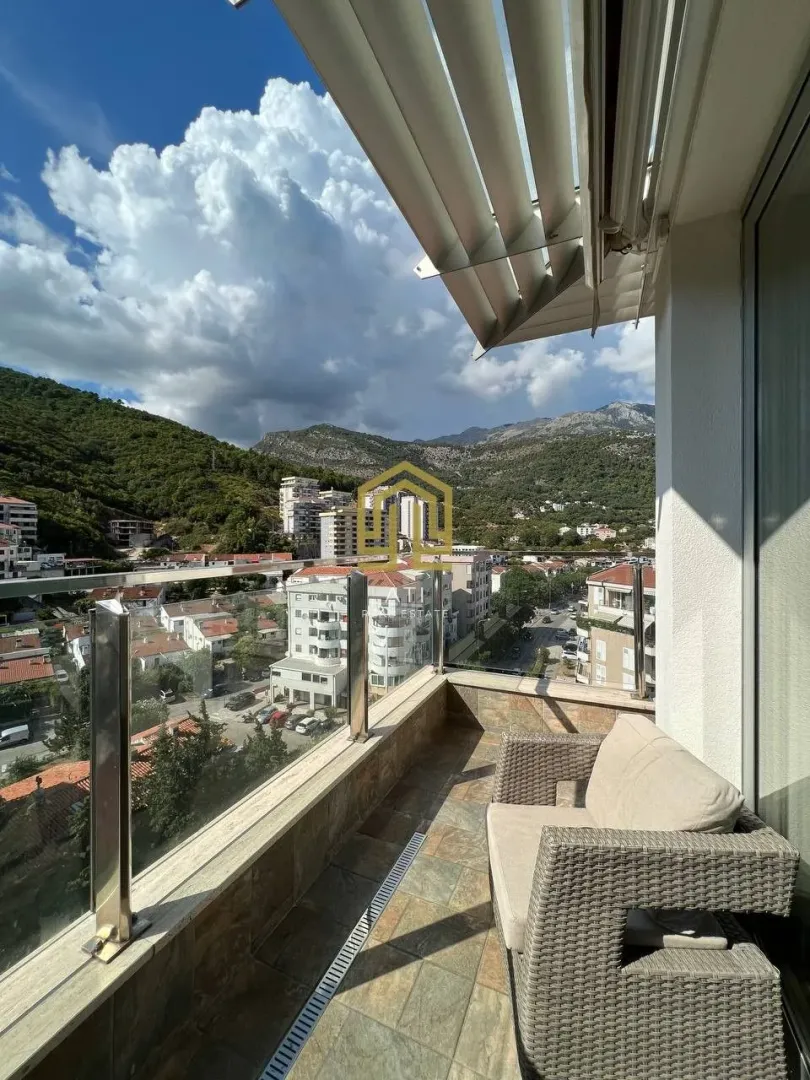 Furnished balcony with seating set and a view of the city and mountains.