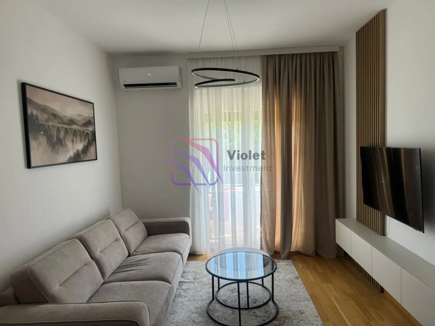Living room with sofa, TV and access to the terrace.