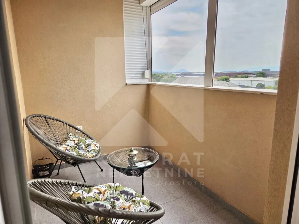 Covered terrace furnished with two armchairs and a small table.