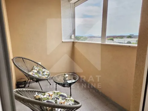 Covered terrace furnished with two armchairs and a small table. - image 6