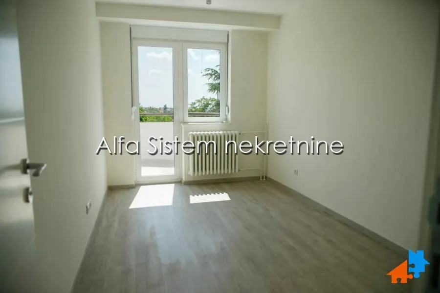 Empty bright room with laminate flooring and access to the terrace.