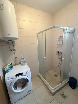 Bathroom with a shower cabin, water heater, and washing machine. - image 7