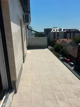 Prostrana popločana terasa sa pogledom na okolne zgrade i ulicu. - image 9