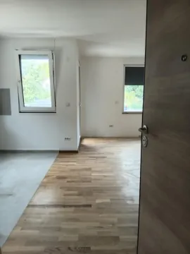 Pogled iz hodnika na nenamještenu prostoriju sa drvenim podom i prozorima. - image 9