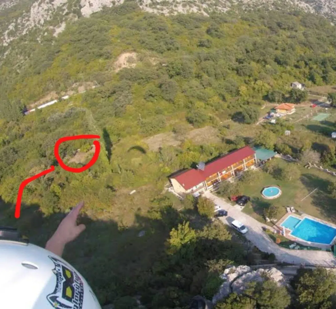 Pogled iz vazduha na imanje sa objektom i bazenom okruženim šumom.