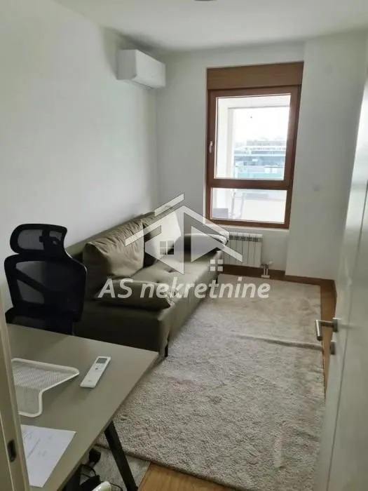 Small living room with a sofa, rug, and desk.