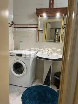 Smaller bathroom with a sink, mirror, washing machine and tiling. - image 4
