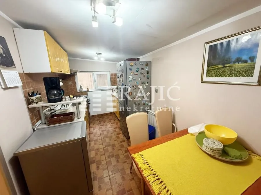 Smaller kitchen with a dining table and yellow details.