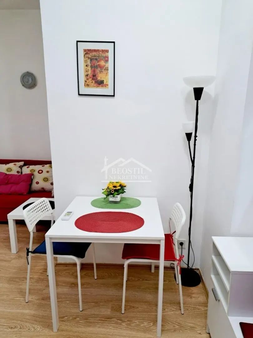 Manji trpezarijski sto sa stolicama u sklopu dnevnog boravka.