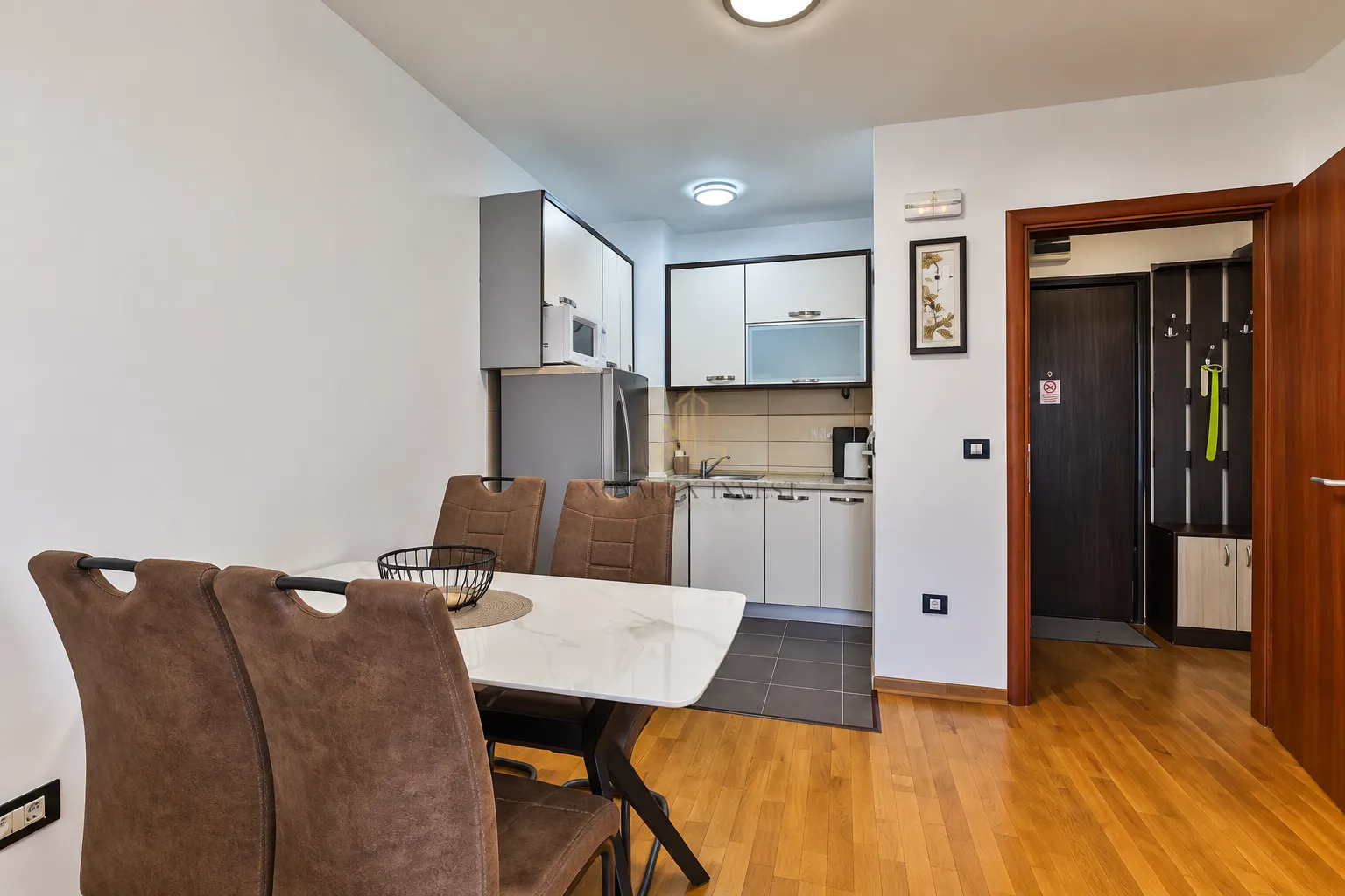 Dining area with a table and chairs and a view of the kitchen.