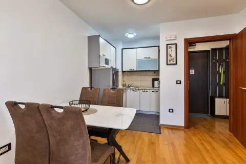 Dining area with a table and chairs and a view of the kitchen. - image 4