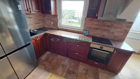 Kitchen with wooden cabinetry, built-in oven and refrigerator. - image 12