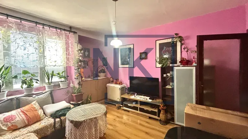 Living room with seating furniture, television, and pink walls.