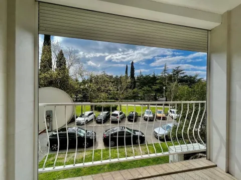 View from the balcony overlooking a parking lot and a nearby park. - image 16