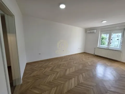 Prazna soba sa parketom i belim zidovima. - image 2
