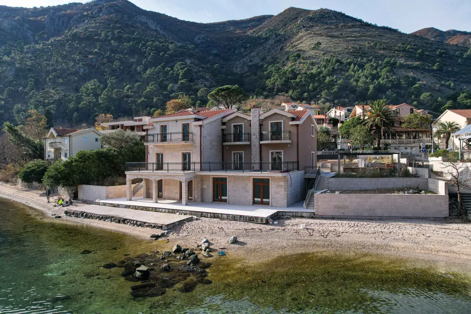 Eksterijer višeporodične kuće sa pogledom na more i plažu.