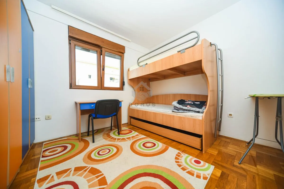 Children's bedroom with a bunk bed, desk, and wardrobe.