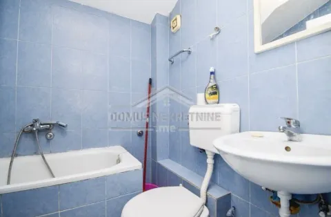A bathroom featuring blue tiling, a bathtub, and a sink. - image 9