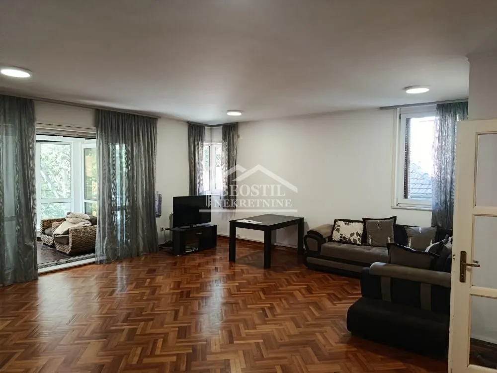 Spacious living room with sofa set, parquet flooring and access to the terrace.