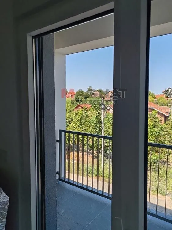 Pogled sa balkona na okolne kuće i zelenilo.