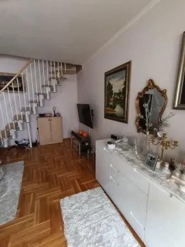 Dnevna soba sa drvenim stepeništem i belom komodom. - image 3