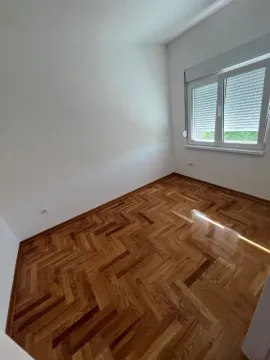 Prazna soba sa belim zidovima i drvenim parketom. - image 5