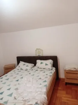 Spavaća soba sa bračnim krevetom i drvenim noćnim stočićima. - image 7