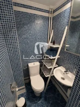 Small bathroom with blue mosaic tiles, toilet, and washbasin. - image 22
