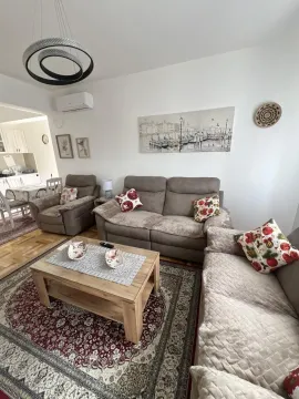 Bright living room with comfortable sofas and a wooden coffee table. - image 7
