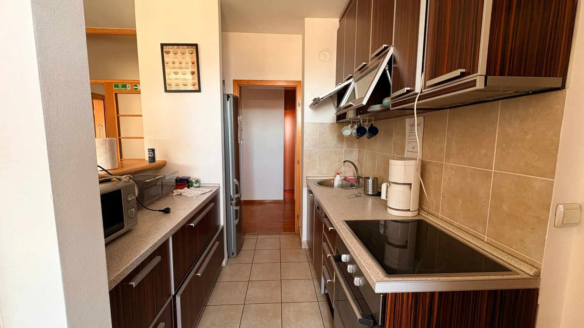 Kitchen equipped with wooden cabinets, appliances, and tile backsplash.