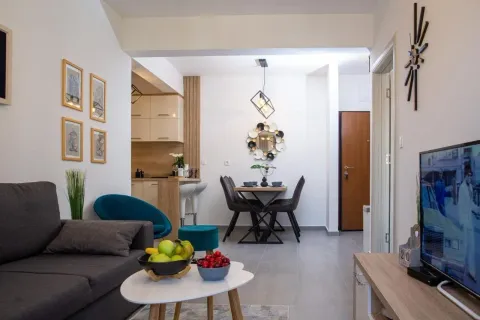 Living room with sofa, dining area, and kitchen in the background. - image 10