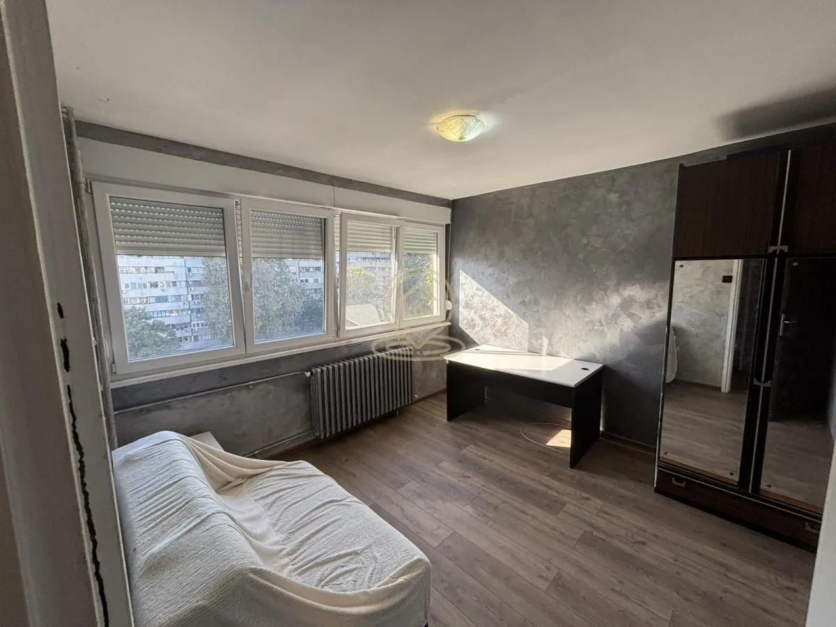 Furnished bedroom with a bed, desk, and wardrobe.