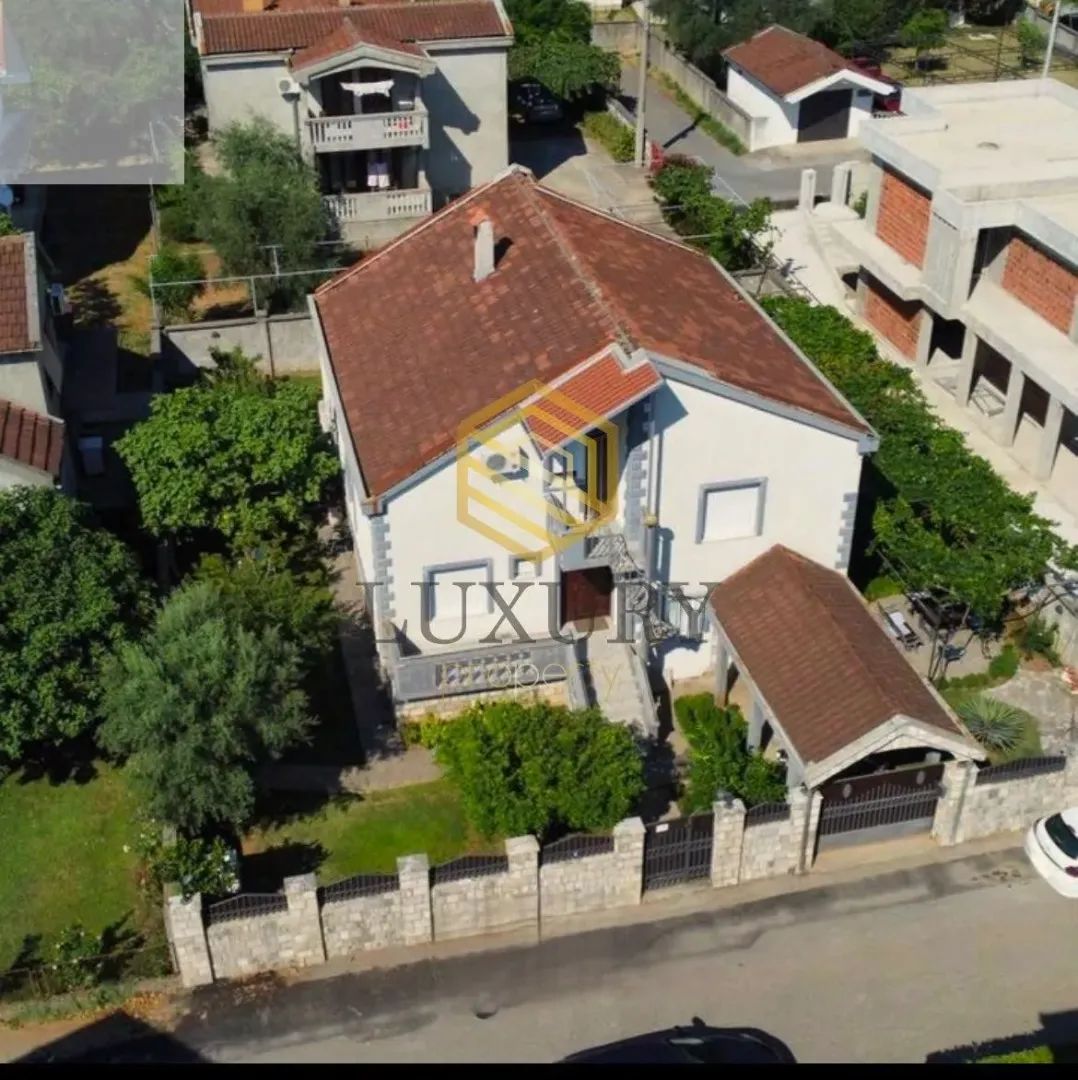 Pogled iz vazduha na kuću sa dvorištem i ogradom.