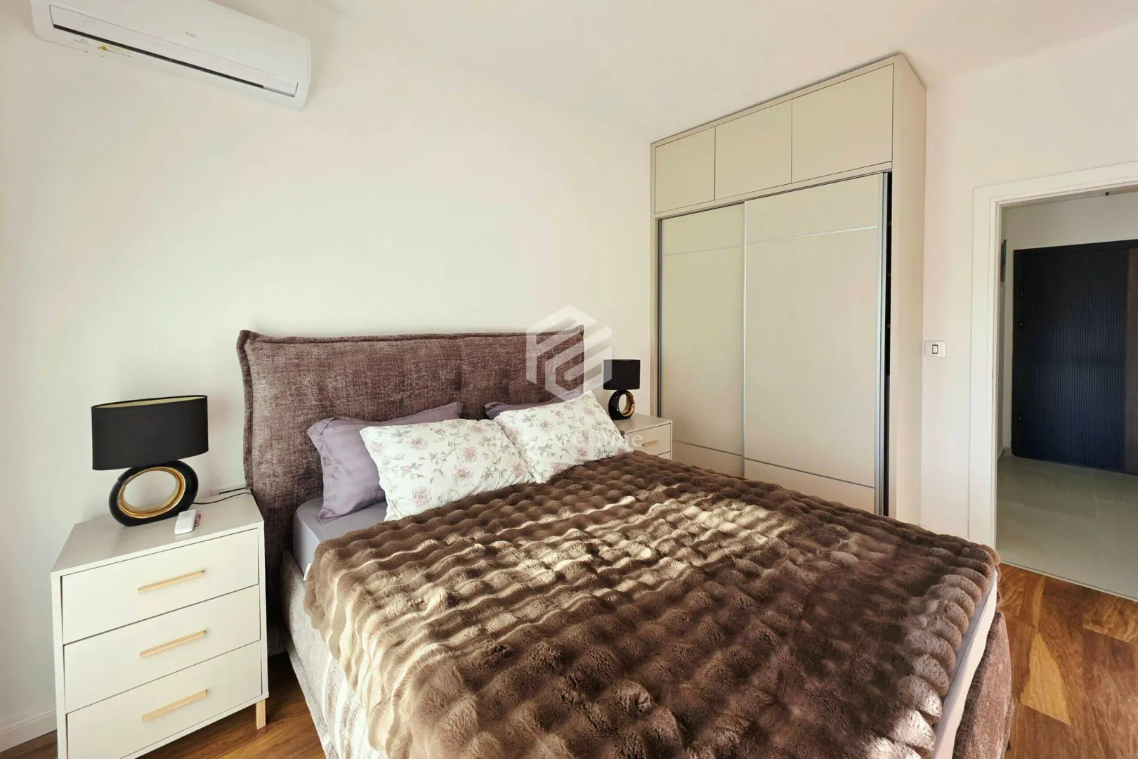 Furnished bedroom with a double bed, wardrobe, and bedside tables.