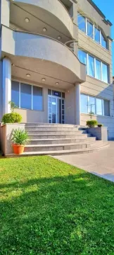 Main entrance and exterior of the building with steps and a landscaped lawn. - image 3
