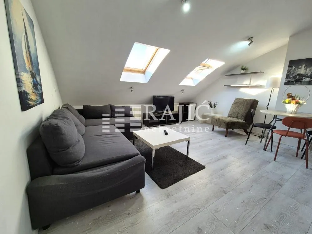 Attic furnished as a living room with sofa set and skylights.