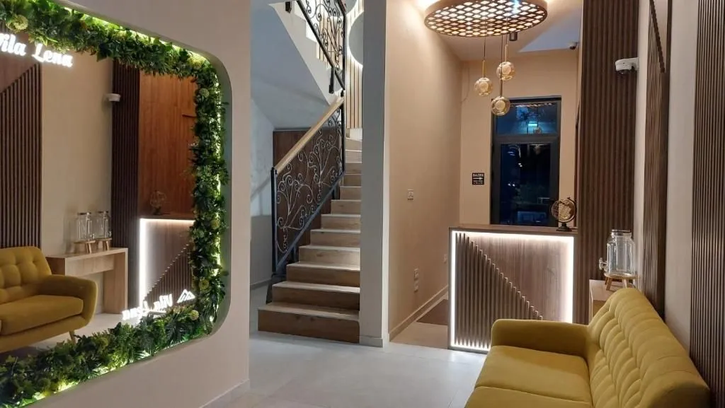 Dnevni boravak sa garniturom, stepeništem i modernim osvetljenjem.