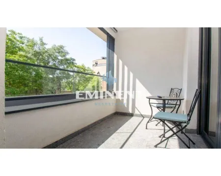 Covered terrace with a table, chairs, and a glass railing. - image 8
