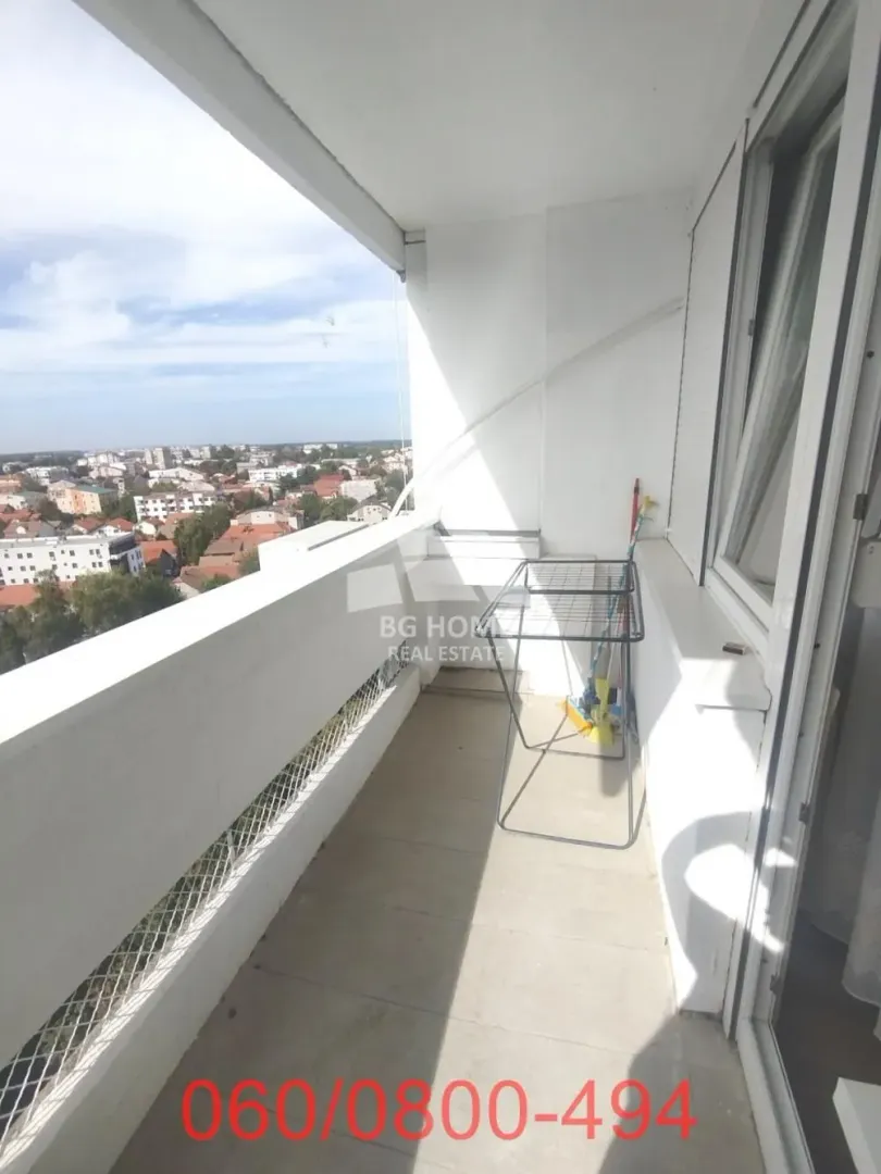Natkriveni balkon sa pogledom na grad i sušačem za veš.