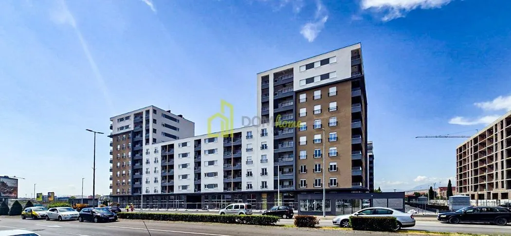 View of the exterior of a modern residential building with a street in the foreground.