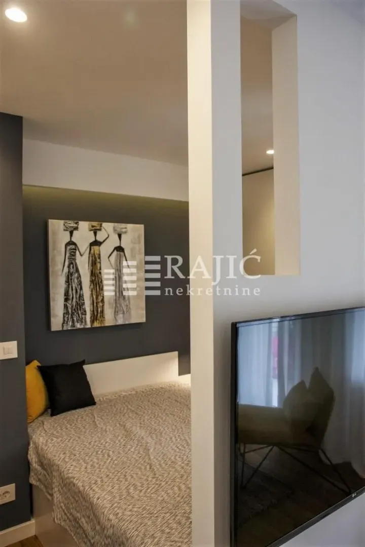 Modern bedroom with a double bed and a wall-mounted TV.