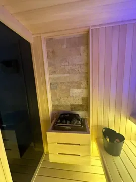 Interior of a sauna with a heater and wooden benches. - image 15