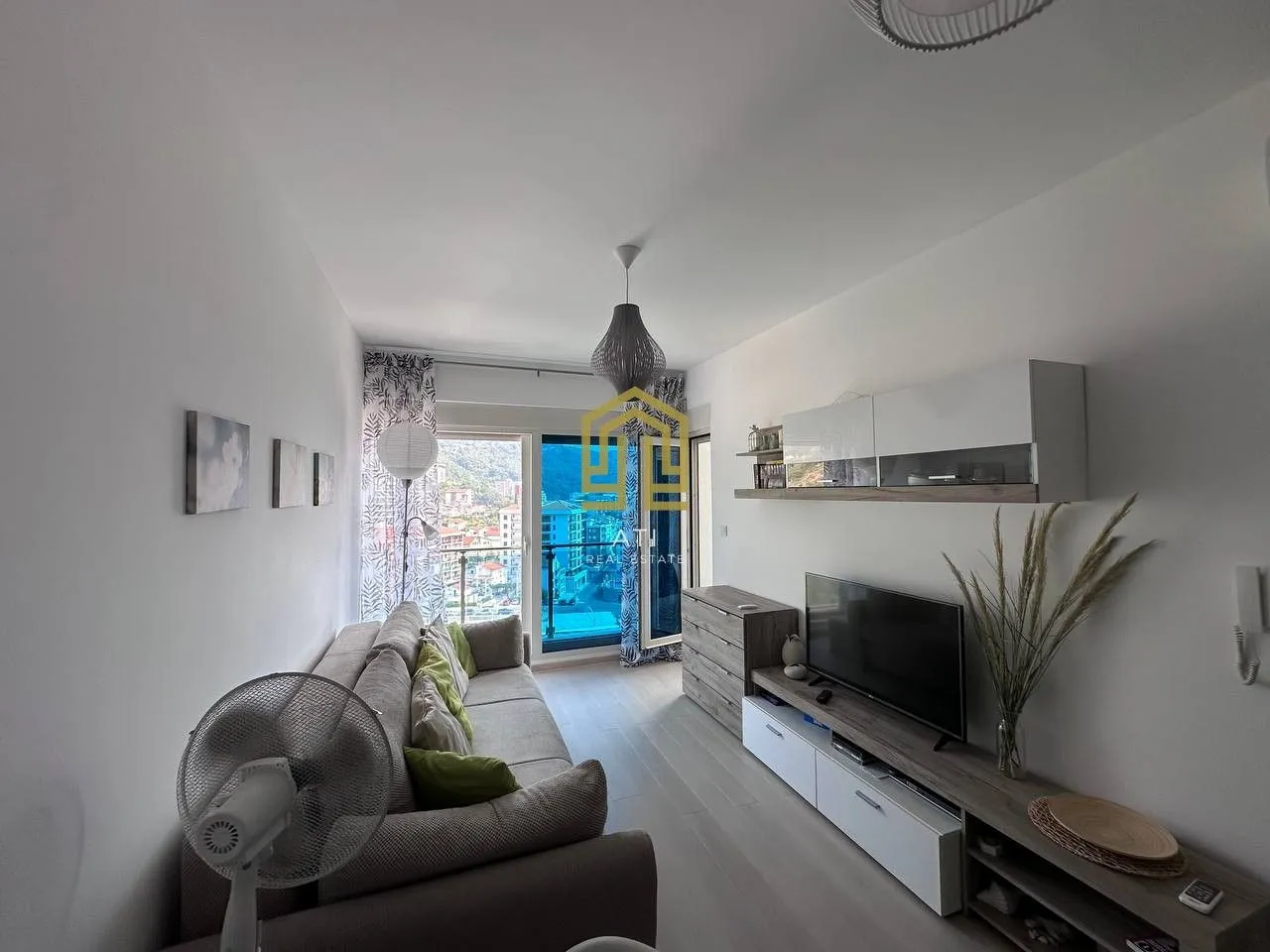 Living room with a sofa, TV, and access to the terrace.